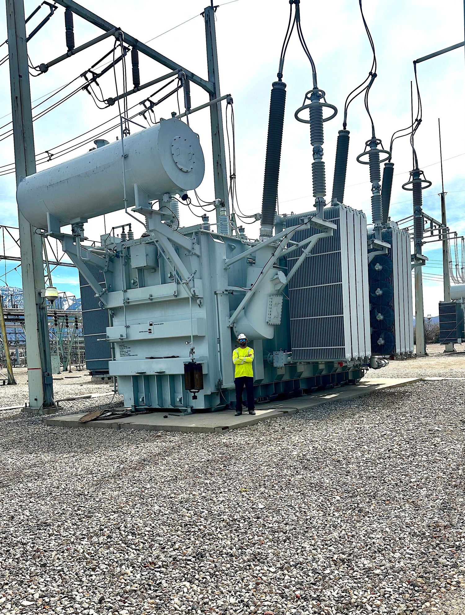 Lineman and owner of ARC Apparel standing in front of transformer in substation