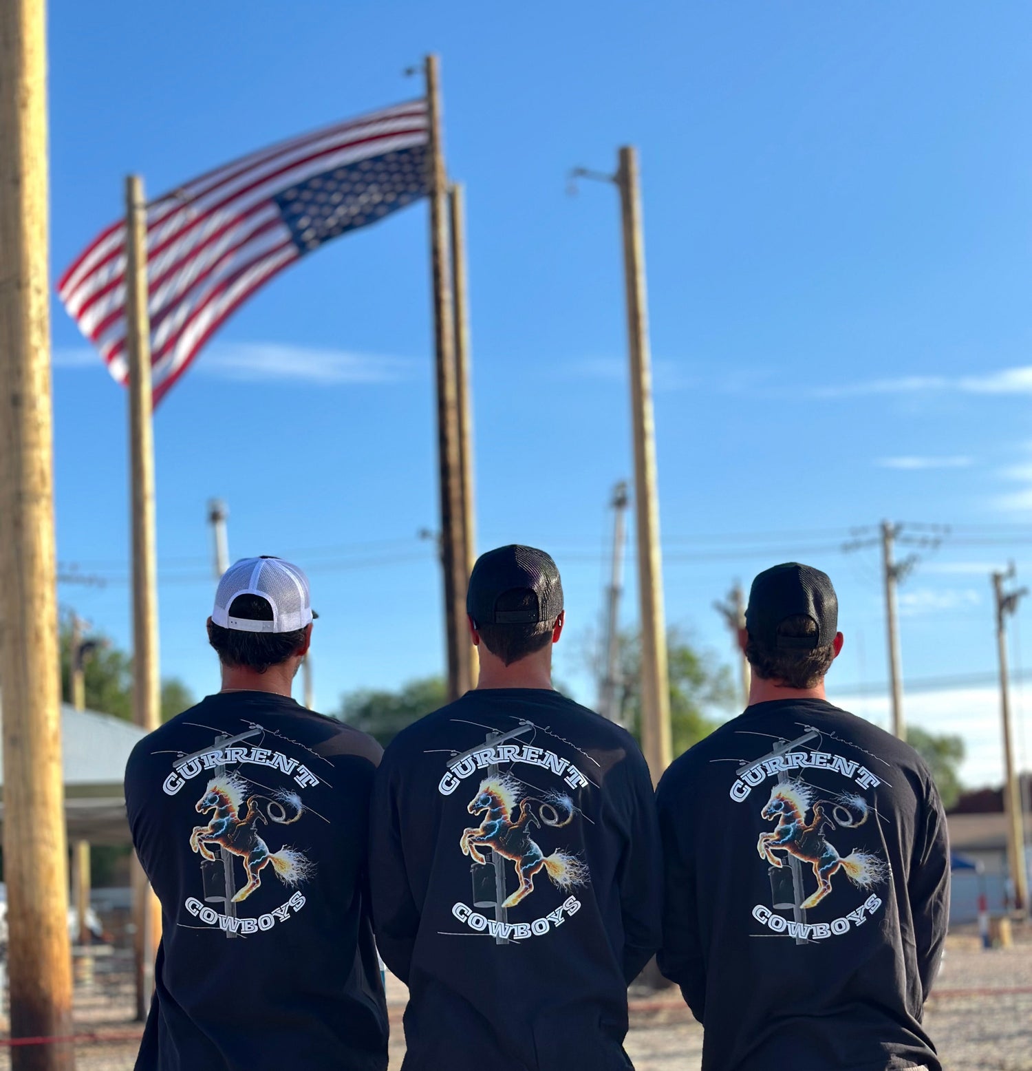 Three linemen wearing lineman shirts from ARC Apparel that say current cowboys. American flag in background.