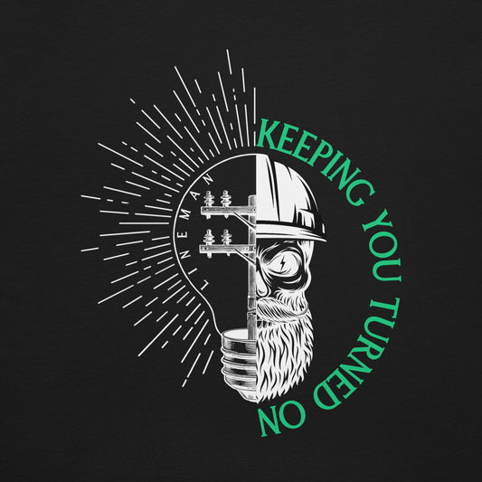Close up Black lineman shirt with lightbulb, power pole, and skeleton in hard hat. Text that reads lineman and keeping you turned on.